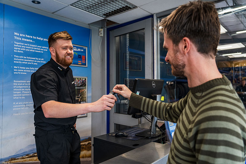 Kwik Fit employee handing keys back